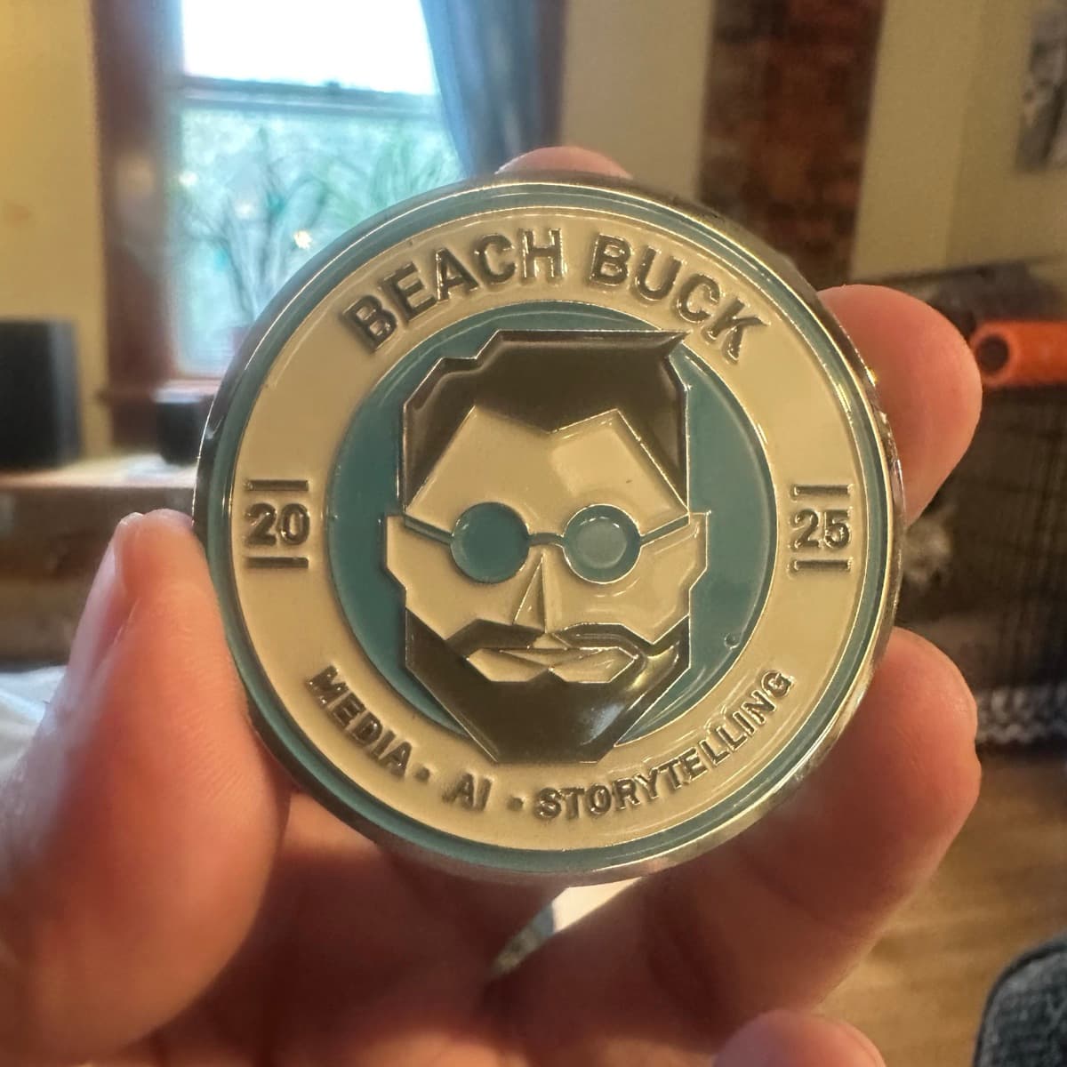 The BEACH BUCK challenge coin held in hand: Media · AI · Storytelling, 2025