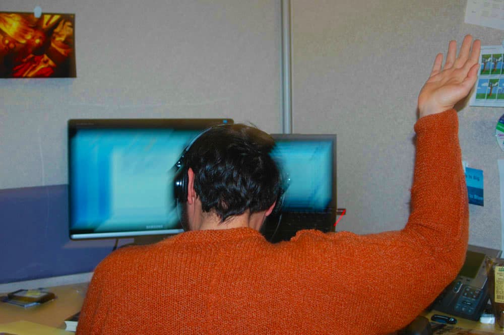 Andy Beach at a desk in headphones, working at dual screens